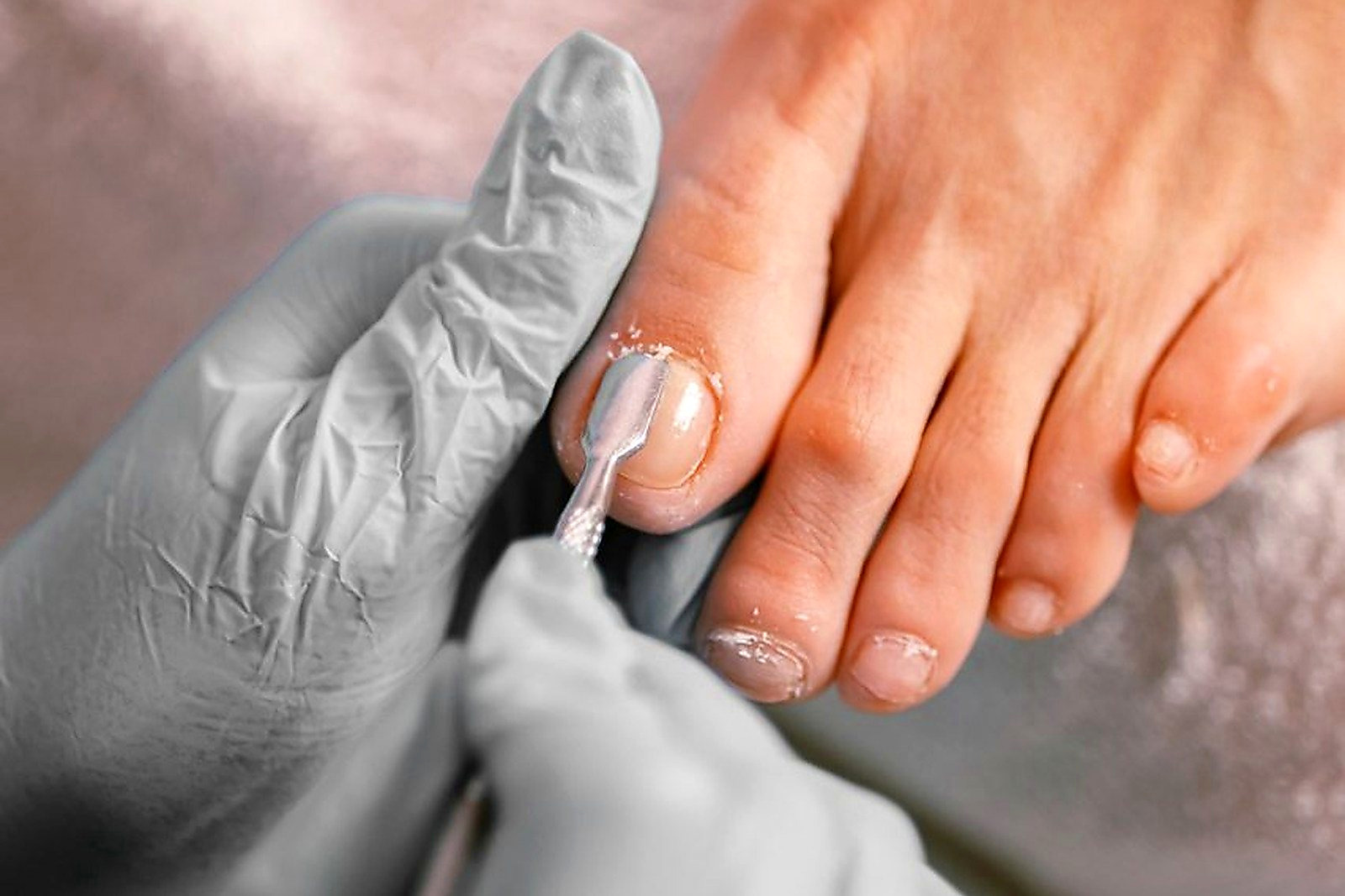 Free Close-up of a beautician applying nail polish on toenails during a pedicure session. Stock Photo