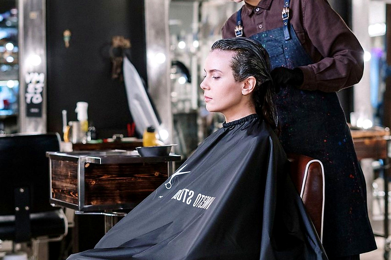 Free Hair stylist working on client's hair at a contemporary salon, providing professional hairdressing services. Stock Photo